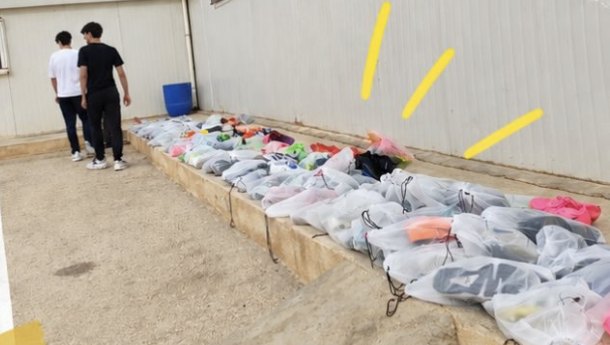 A long row of bagged boots laid out along a wall before handing them over